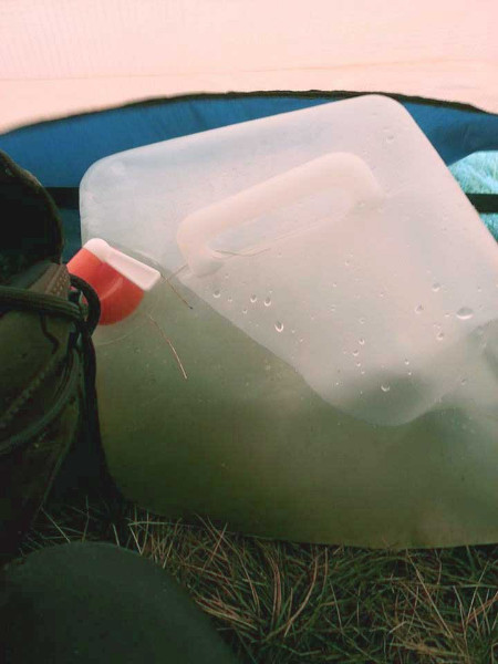 A transparent water carrier filled with dirty water