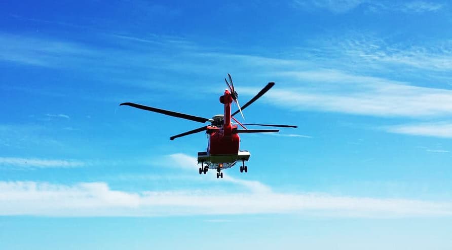 Photo Album: Irish Coast Guard Rescue Helicopter CH-47 Chinook helicopter flying in clear blue sky, aerial view, aviation, heavy-lift helicopter, military aircraft.