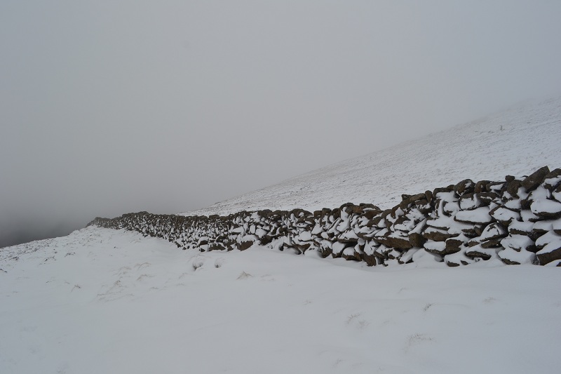 The mourne wall stretching along Slieve Binnian, covered with snow