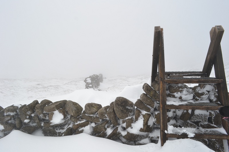 a stile crossing the Mourne wall covered in snow