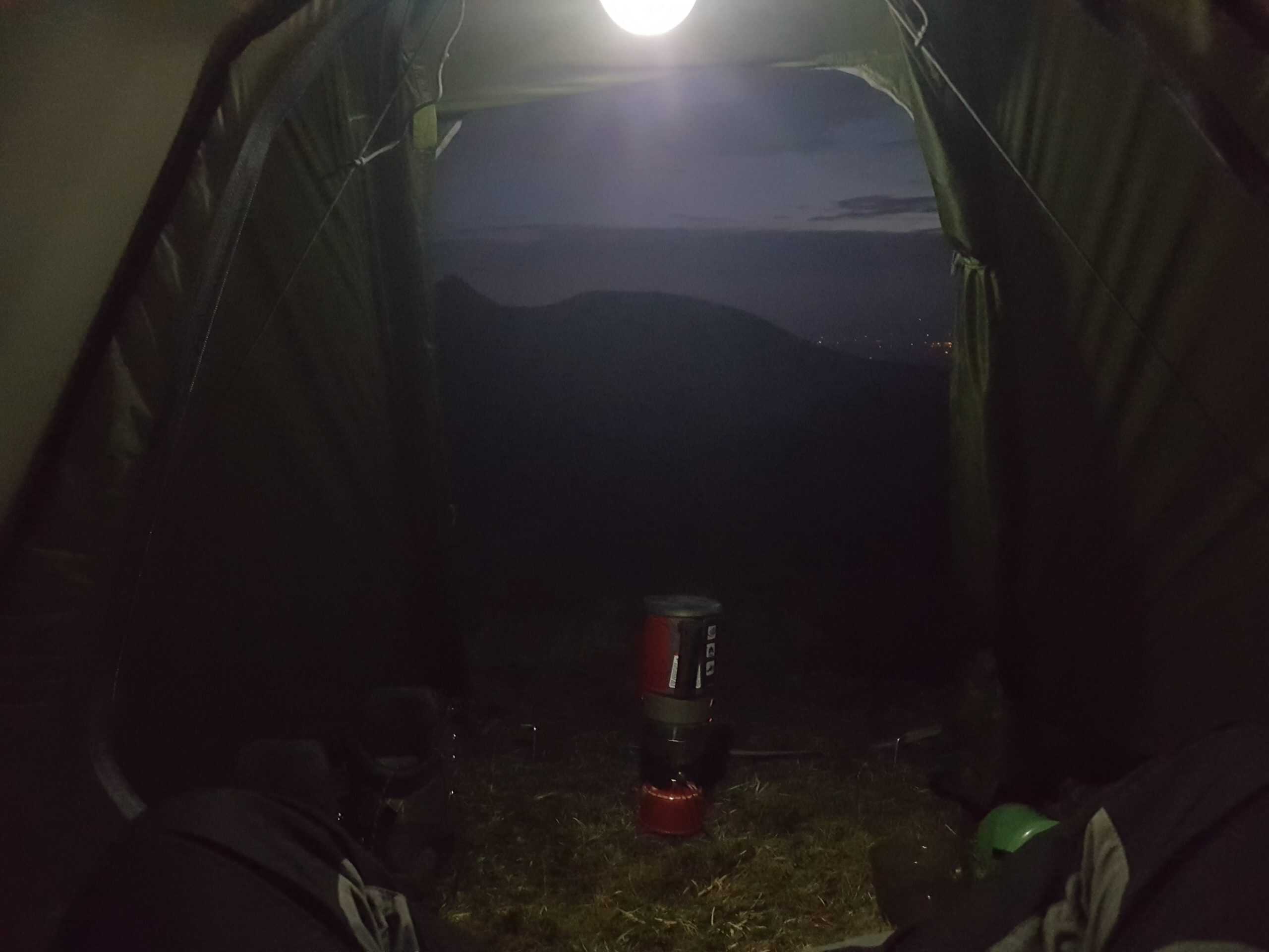 Breathtaking lakeside mountain landscape with rolling green hills and rugged terrain during daytime.