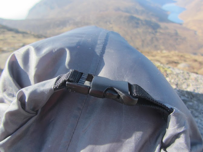 Breathtaking lakeside mountain landscape with rolling green hills and rugged terrain during daytime.