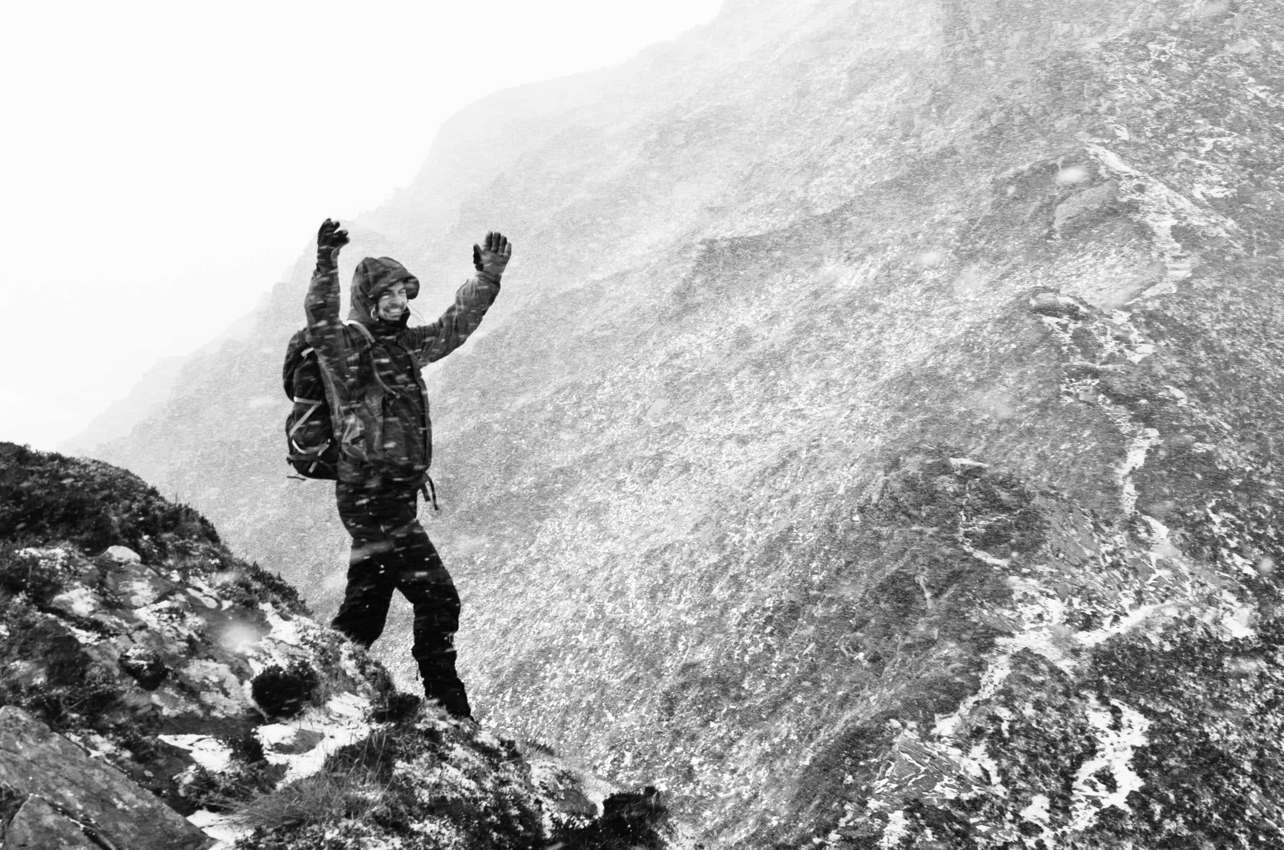Photo Album: Winter in Donegal Rugged hiker standing on a mountain trail in snowy weather, dressed in waterproof gear, enjoying outdoor adventure and mountain exploration in harsh conditions.
