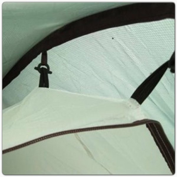 Walking hikers on a scenic rural trail with backpacks in open countryside under a blue sky.