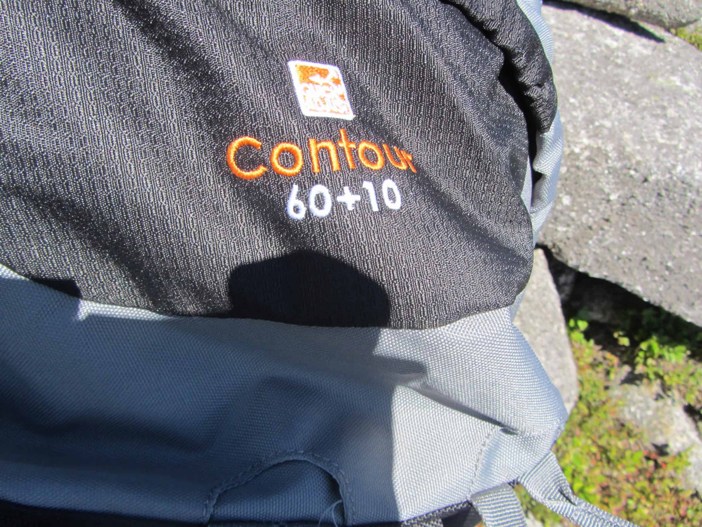 Breathtaking lakeside mountain landscape with rolling green hills and rugged terrain during daytime.