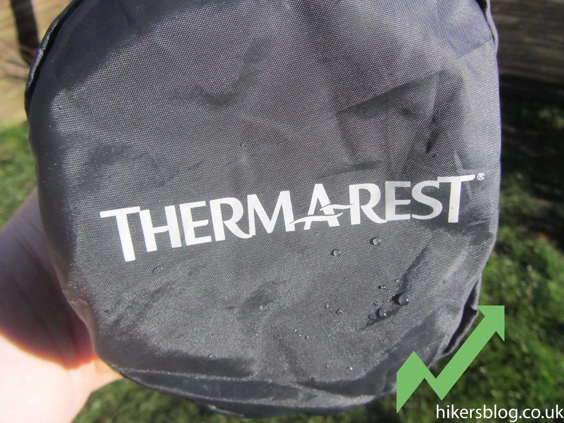 Waterproof thermarest backpack cover with rain droplets, outdoor gear, hiking accessory for weather protection.