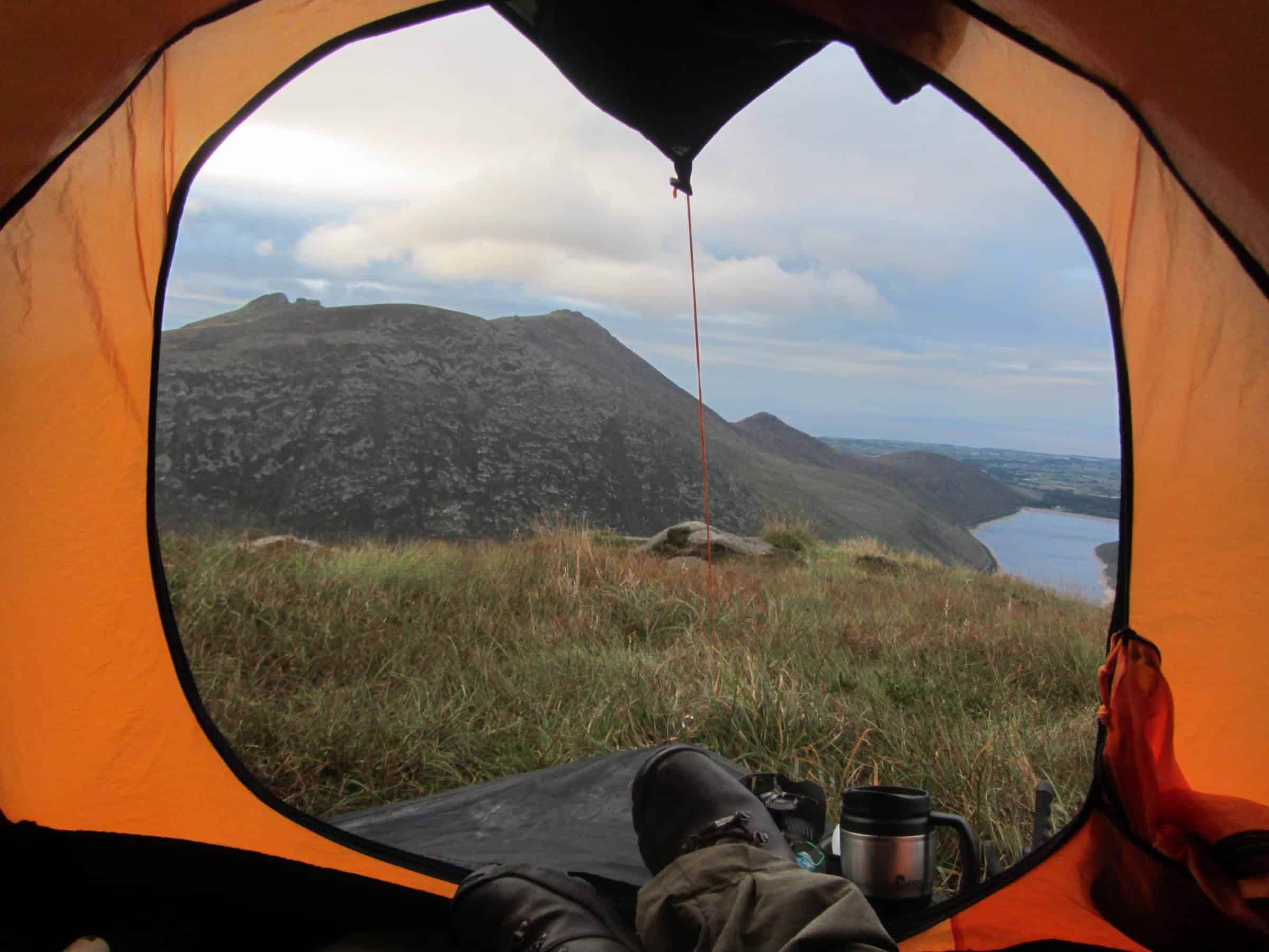 Video: Doan summit camp Scenic view from inside a camping tent overlooking a mountain landscape with a lake in the distance, ideal for outdoor hiking adventures.