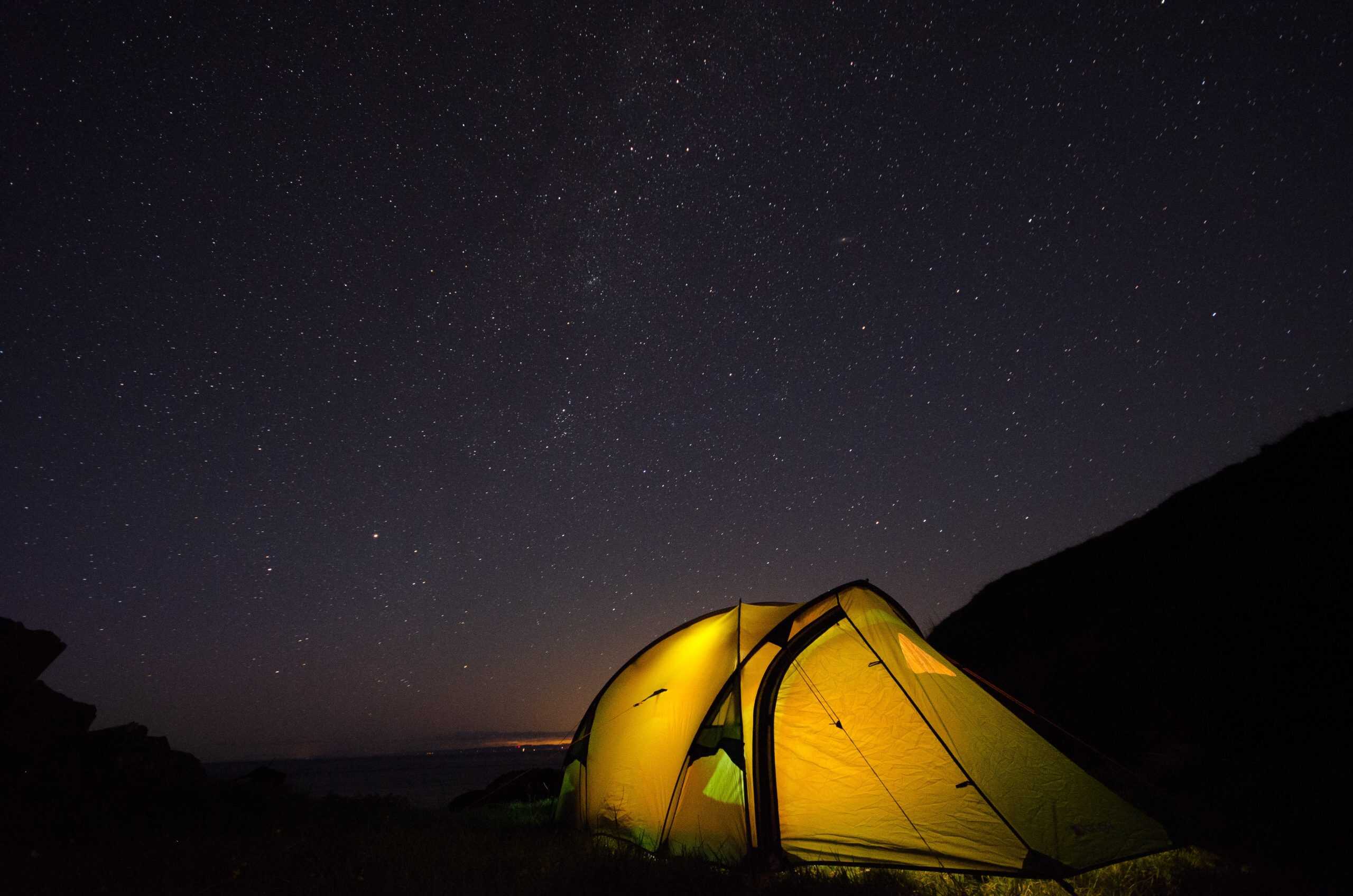 Vango Nemesis 200 Review Starry night sky over a camping tent on a mountain trail, perfect for outdoor adventure and stargazing.